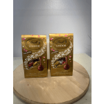 Two Lindt Lindor assorted chocolate truffle boxes on a round wooden board
