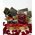 Gift box with red rose petals, candles, and Godiva chocolates