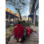 Bouquet of red roses wrapped in black paper with a red ribbon