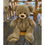 Large plush teddy bear with a plaid ribbon bow