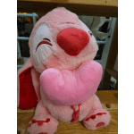 Pink plush teddy bear holding a heart pillow