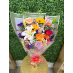 Colorful wrapped bouquet with lilies, roses, sunflowers, and mixed blooms tied with a red ribbon