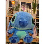 Large blue plush Stitch toy sitting in a flower shop display