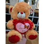 Plush teddy bear holding a heart with "I Love You" text