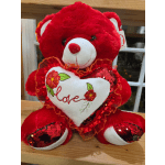 Red teddy bear holding a white heart with the word love