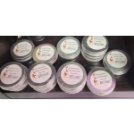 Stacks of labeled lotion bars in round plastic containers