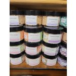 Stacked jars of whipped shea butter soap in assorted pastel colors