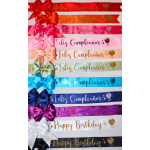 Stack of colorful birthday ribbons with bows and glitter text