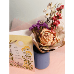 Bouquet of dried flowers in a blue vase beside a sympathy card