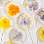 Clear lollipops with pressed yellow and purple flowers and gold flakes inside