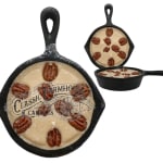 Three skillet-shaped candles with a cream wax surface and pecan decorations