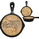 Three skillet-shaped candles with beige wax and speckled tops