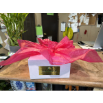 White gift box wrapped with bright pink tissue paper