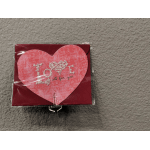 Heart-shaped pink card with the word "LOVE" on a red envelope