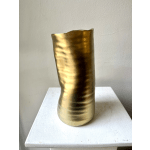 Gold metallic vase on a white surface