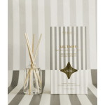 Reed diffuser in a glass bottle beside its striped box
