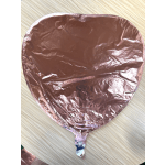 Rose gold heart-shaped foil balloon on a light wood surface