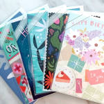 Assorted colorful greeting cards stacked in plastic sleeves