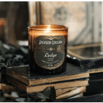 Lit amber candle in a glass jar on stacked books