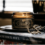 Amber glass candle jar with a black label on a tray