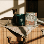 Candle, trophy, and decorative box on a suitcase with a map cloth