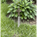 Metal cross wind chime hanging from a garden stake