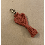 Macrame heart keychain with a tassel on a beige background