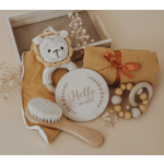Baby gift set with a crocheted lion, wooden sign, blanket, and teether