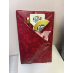 Red gift bag with cards and a gold pen inside