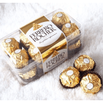 Clear plastic box of gold-wrapped Ferrero Rocher chocolates on white fabric