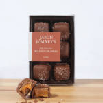 Box of milk chocolate sea salt caramels with two pieces cut open in front
