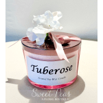 Pink candle jar with a white flower and ribbon on top
