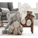 Three plush stuffed animals sit together in a bright room.
