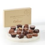 Box of assorted chocolates with pieces arranged on a white tray