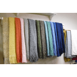 Row of colorful knitted scarves hanging on a wall rack
