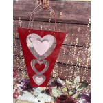Red heart-themed gift bag with silver handles and layered heart cutouts
