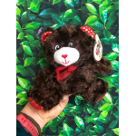 Brown teddy bear with a red bow held in a hand