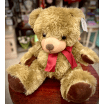 Plush teddy bear with a red ribbon around its neck