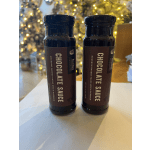 Two bottles of chocolate sauce on a table