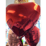 Red heart-shaped foil balloons with a birthday balloon behind them