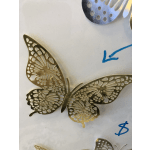 Gold butterfly-shaped metal wall decor with cutout wing patterns