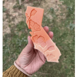 Hand holding a peach-orange floral silicone mold