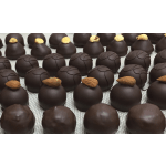 Rows of dark chocolate truffles, some topped with almonds and hazelnuts, on a mesh tray