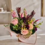 Bouquet of pink and purple flowers wrapped in pale pink paper