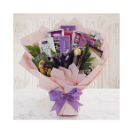 Gift bouquet of assorted chocolates and snacks wrapped in pink paper with a purple bow