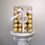 Box of Ferrero Rocher chocolates tied with a white ribbon