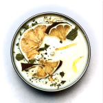 Round candle with dried citrus slices and herb pieces on top