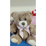 Brown plush teddy bear with a pink ribbon bow