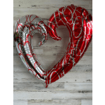 Two heart-shaped foil balloons, one red and one silver, with heart patterns