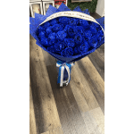 Bouquet of vivid blue roses wrapped in blue paper with a ribbon